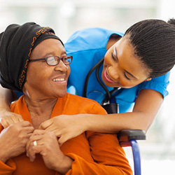 an elderly woman smiling with a young caregiver