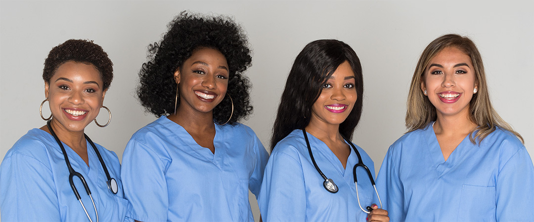 Multi-racial group of nurses wearing blue scrubs